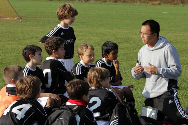 a coach talks to soccer players