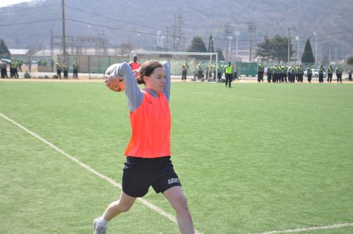 an army soccer player takes a throw in